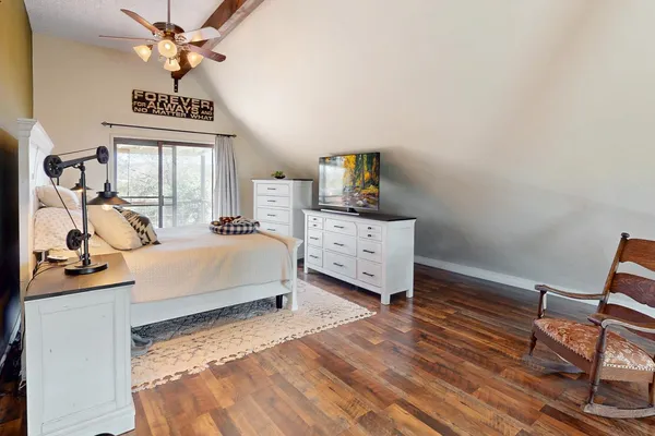 a spacious bedroom with a bed couch and a window