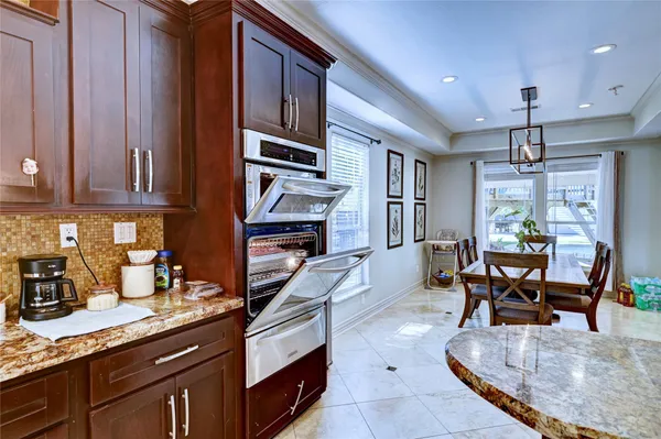 a living room with stainless steel appliances granite countertop furniture a rug kitchen view and a counter top space