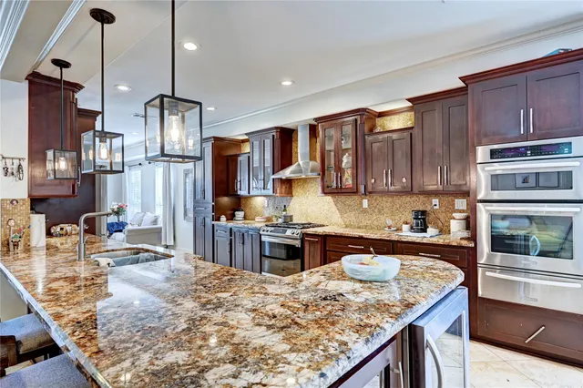 a kitchen with stainless steel appliances granite countertop a stove refrigerator and cabinets