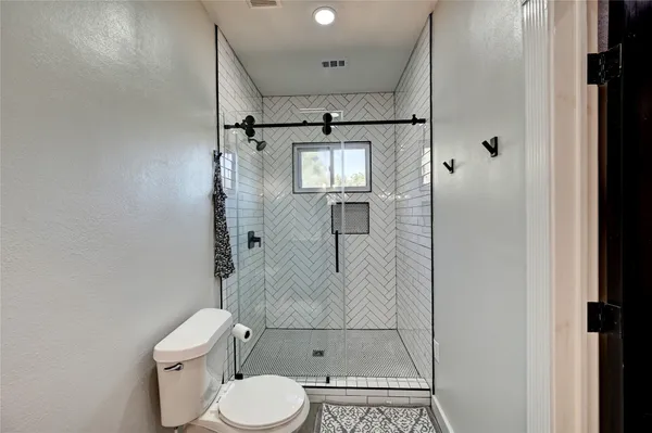 a bathroom with a toilet and a shower