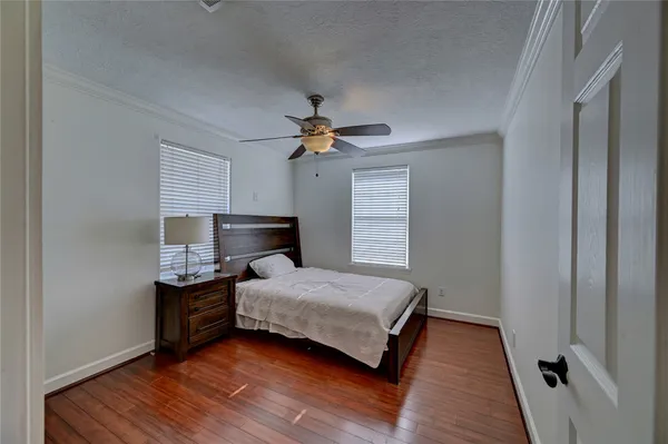 an empty room with windows and ceiling fan