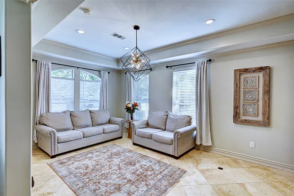 a living room with furniture and a chandelier