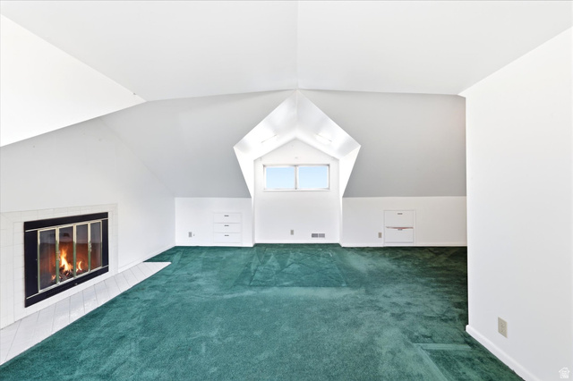 292 West 400 South Springville, UT 84663 - Photo 30 of 37 Spacious attic room featuring a fireplace with a white tile hearth, built-in storage drawers, and a window dormer