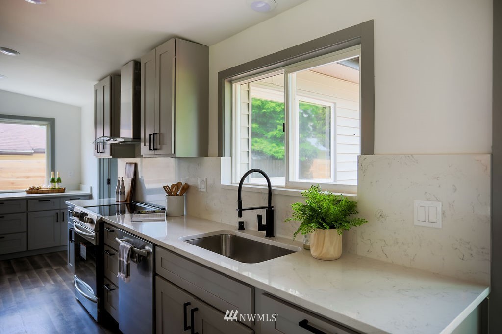 10910 Southeast 181st Street Renton, WA 98055 - Photo 14 of 32 a kitchen with a sink a counter top space and cabinets