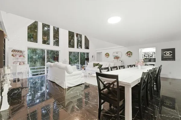 a living room with furniture a dining table and a stove with wooden floor