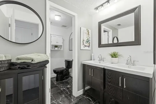 a bed sitting in a bedroom next to a window and a potted plant