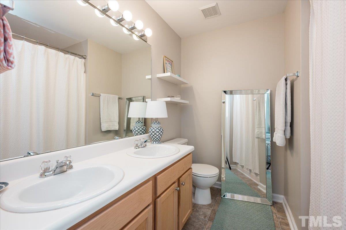 1707 Grace Brook Road Raleigh, NC 27609 - Photo 13 of 17 a bathroom with a double vanity sink and a mirror
