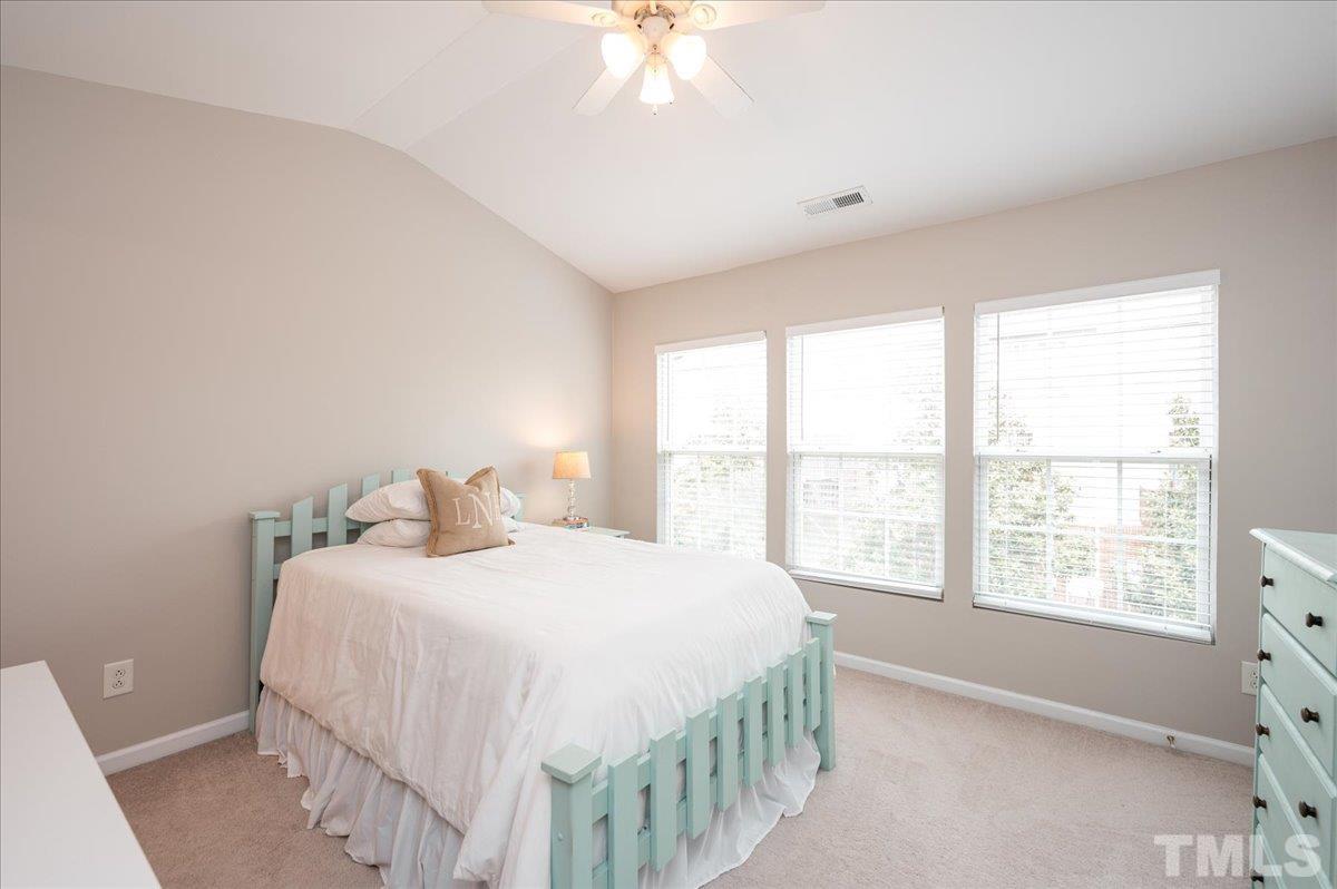 1707 Grace Brook Road Raleigh, NC 27609 - Photo 14 of 17 a bedroom with a bed and a chandelier