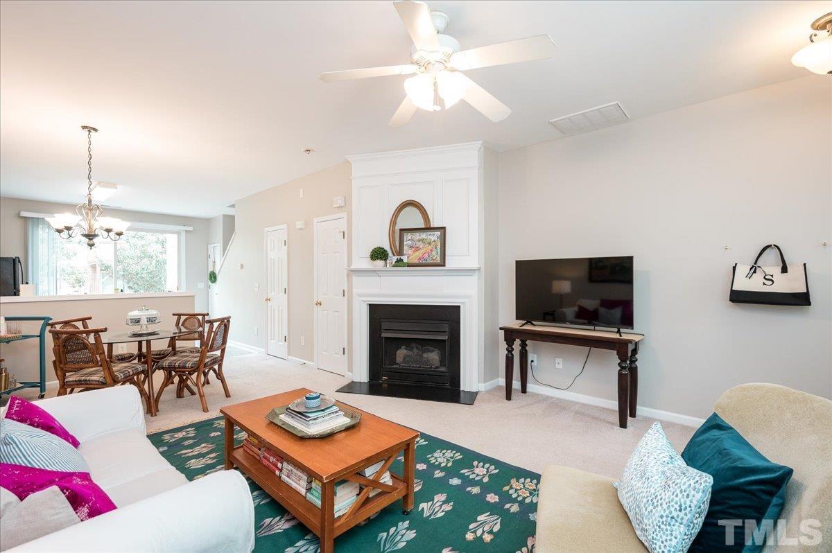 1707 Grace Brook Road Raleigh, NC 27609 - Photo 3 of 17 a living room with furniture a fireplace and a flat screen tv
