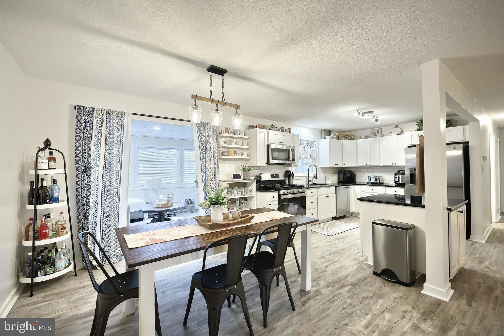 56 York Road York, PA 17407 - Photo 9 of 45 a kitchen with stainless steel appliances kitchen island granite countertop a dining table chairs and white cabinets