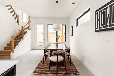 a dining room with wooden floor and a rug