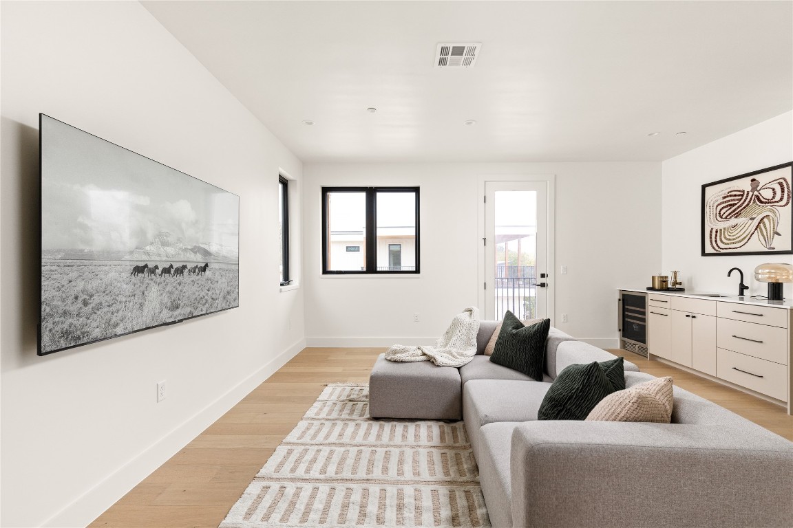 4416 South 1st Street, Unit 2 Austin, TX 78745 - Photo 32 of 40 Living room with light wood-style floors, bar with sink, and wine cooler