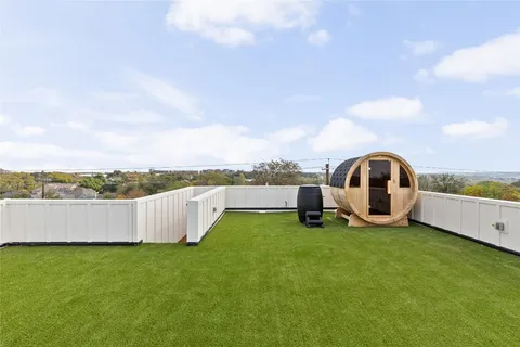 a view of a garden with lawn chairs and a large tree