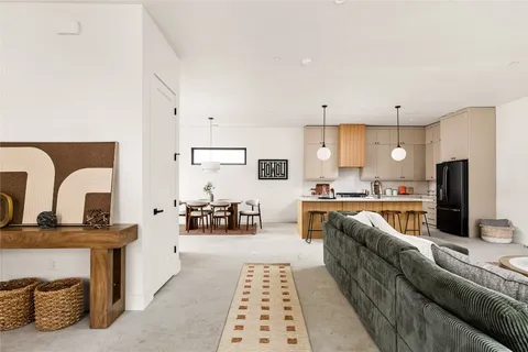 a large living room with stainless steel appliances kitchen island granite countertop furniture and a fireplace