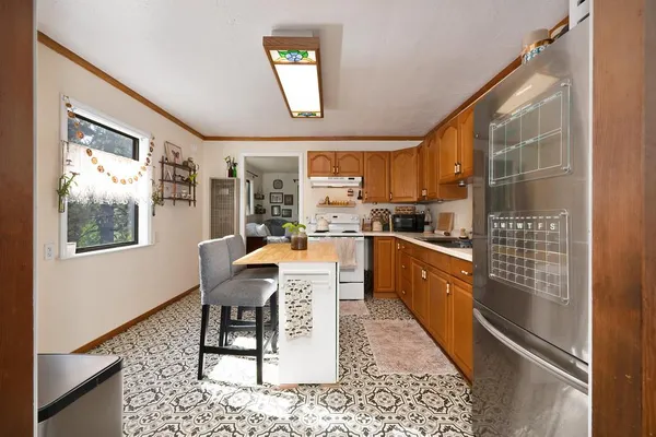 a kitchen with a table chairs refrigerator and window