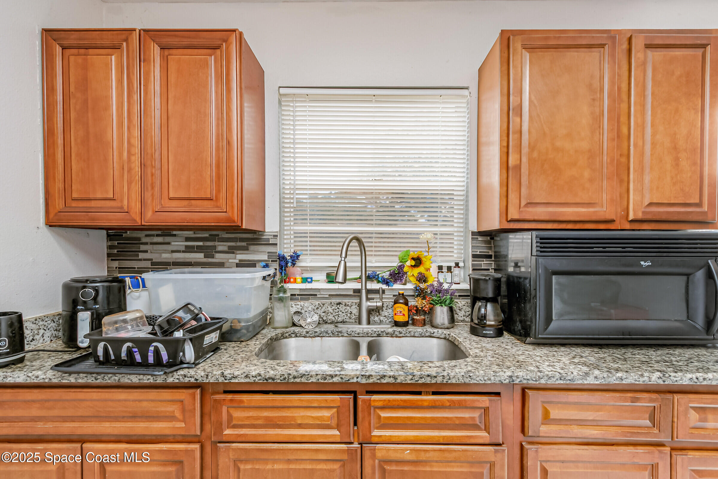 2465 Sarno Road Melbourne, FL 32935 - Photo 4 of 24 a kitchen with granite countertop stainless steel appliances a sink a stove a microwave and cabinets