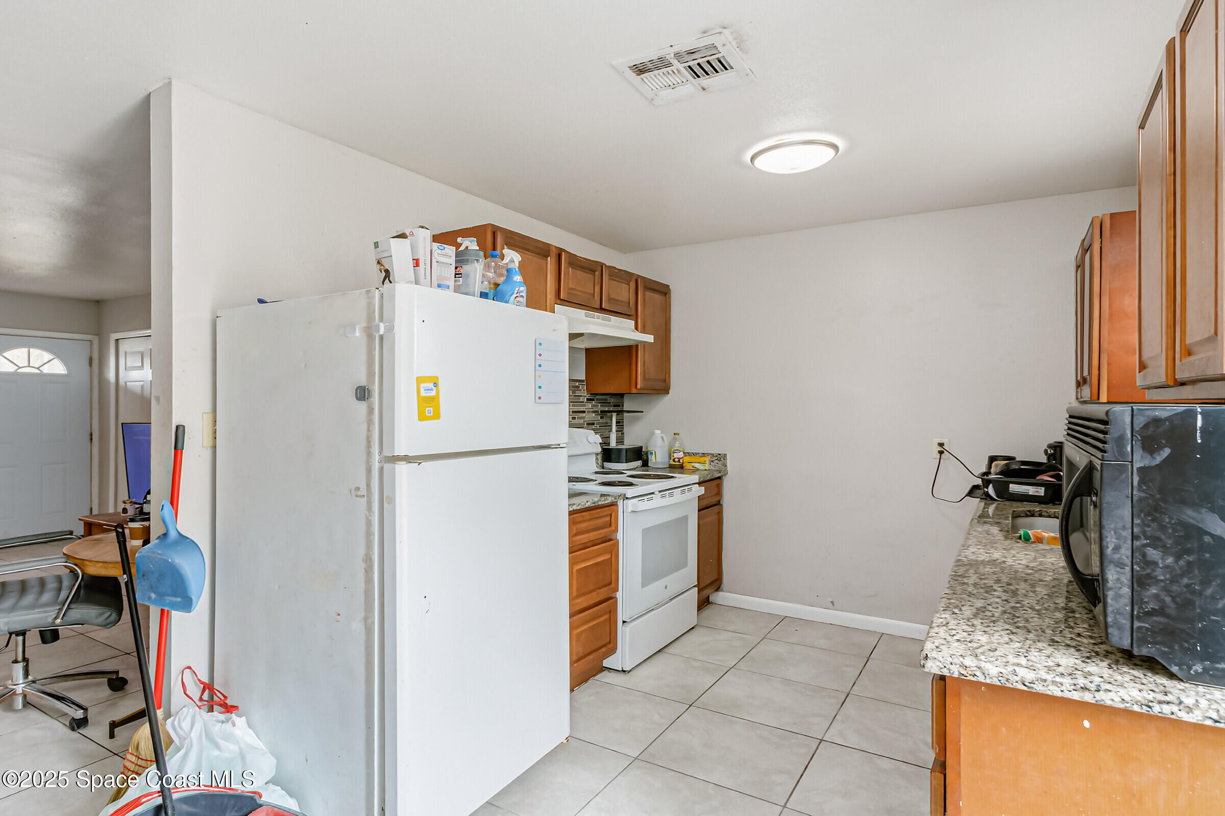 2465 Sarno Road Melbourne, FL 32935 - Photo 6 of 24 a kitchen with stainless steel appliances granite countertop a refrigerator and a sink