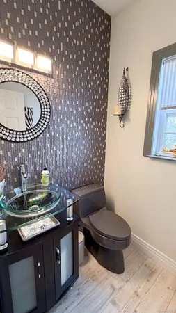 a bathroom with a toilet a sink and mirror