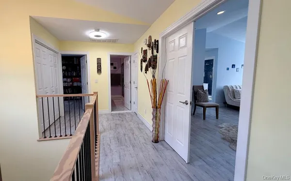 a view of a hallway with wooden floor and stairs