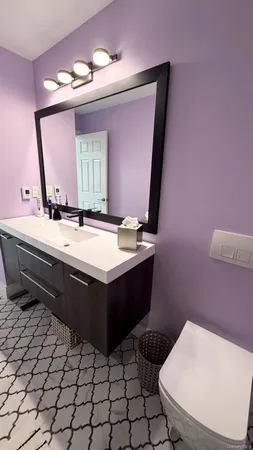 a bathroom with a sink mirror vanity and toilet