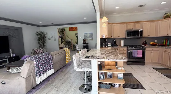 a living room with furniture a flat screen tv and kitchen view