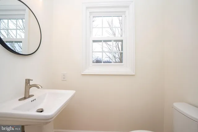a spacious bathroom with a double vanity sink toilet mirror and shower