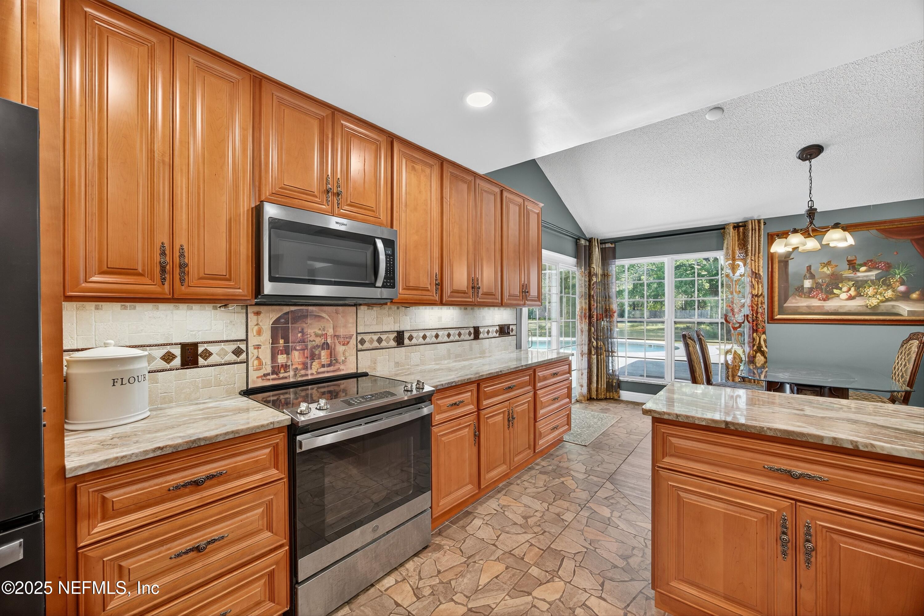 11341 V C Johnson Road Jacksonville, FL 32218 - Photo 17 of 70 a kitchen with stainless steel appliances granite countertop a sink stove microwave and cabinets