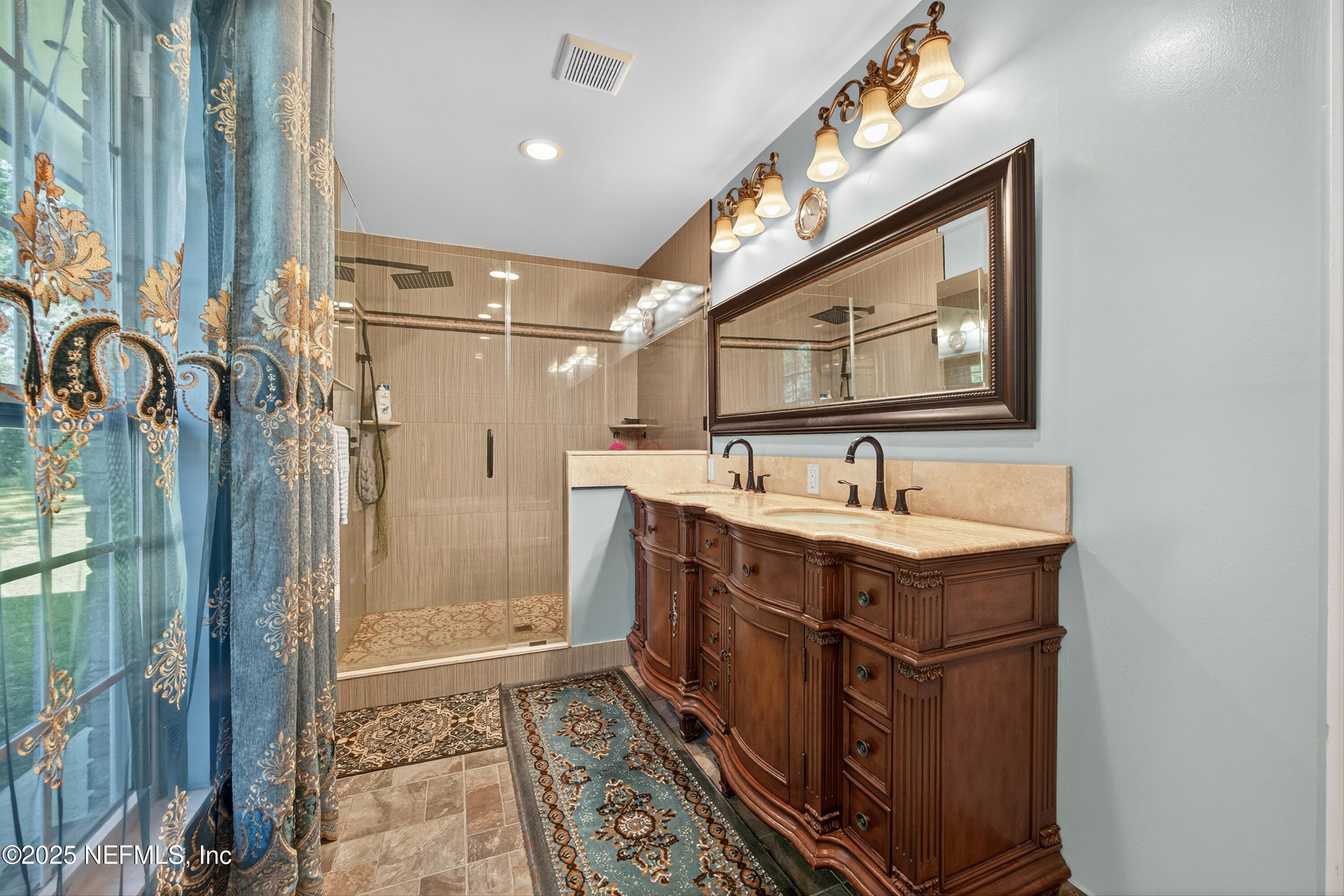 11341 V C Johnson Road Jacksonville, FL 32218 - Photo 21 of 70 a bathroom with a sink a mirror a vanity and shower