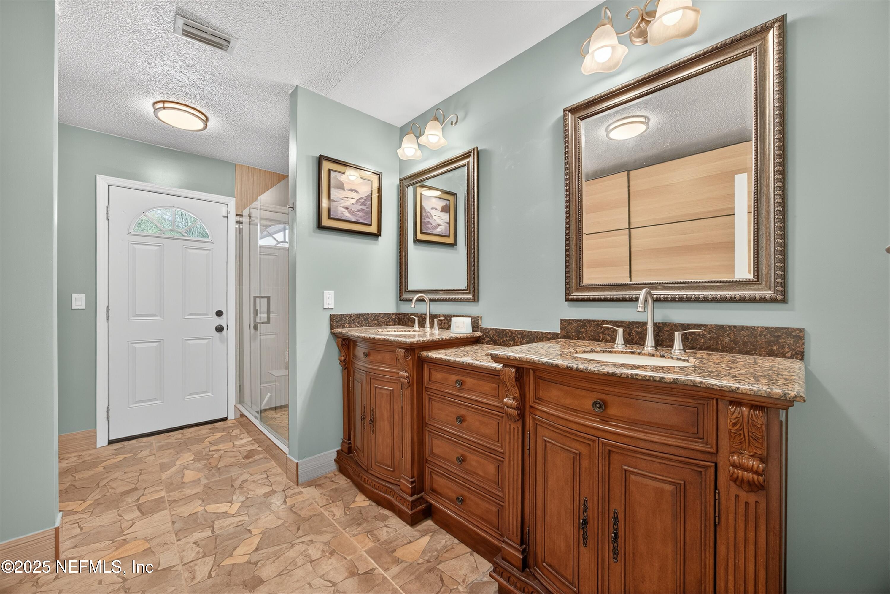 11341 V C Johnson Road Jacksonville, FL 32218 - Photo 26 of 70 a spacious bathroom with a granite countertop sink a mirror a vanity and a