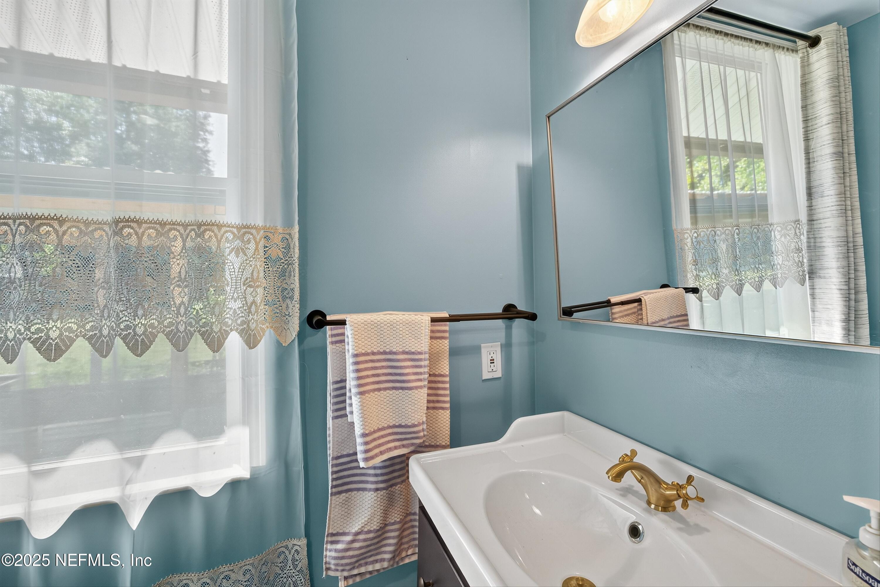 11341 V C Johnson Road Jacksonville, FL 32218 - Photo 53 of 70 a bathroom with a sink a mirror and a shower