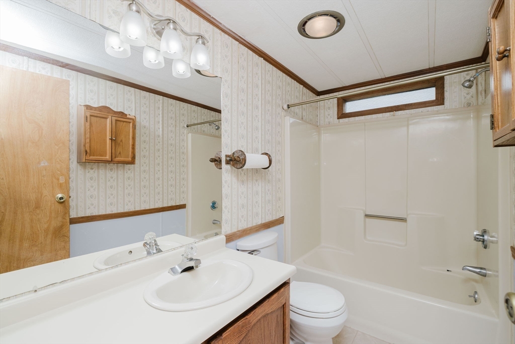 4 Tucker Terrace Raynham, MA 02767 - Photo 17 of 29 a bathroom with a sink a toilet a mirror and shower