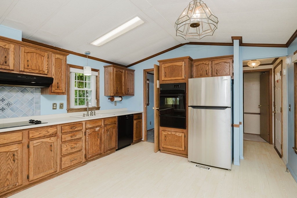 4 Tucker Terrace Raynham, MA 02767 - Photo 8 of 29 a kitchen with granite countertop a refrigerator a sink and dishwasher a oven with wooden cabinets
