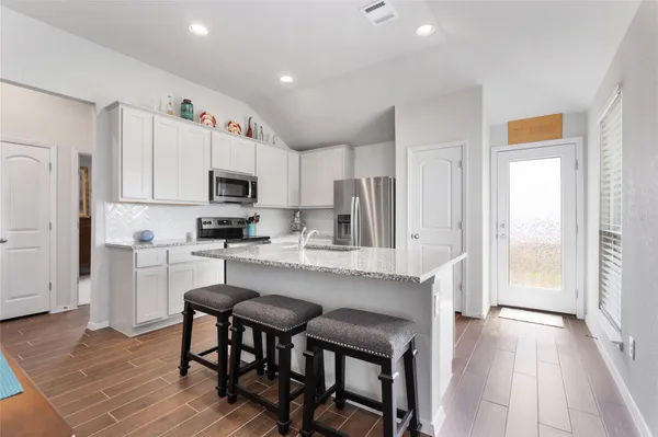 a kitchen with white cabinets and stainless steel appliances