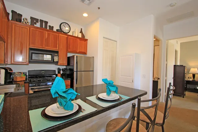 a view of kitchen that has dining table and chairs