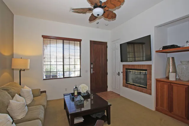 a living room with furniture a flat screen tv and a fireplace