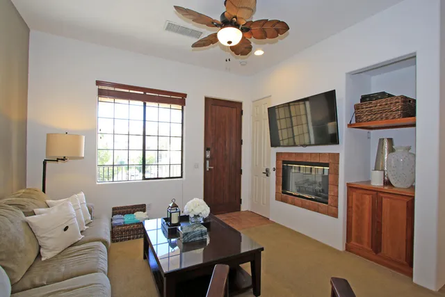 a living room with furniture a flat screen tv and a window