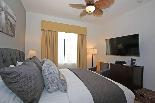 a bedroom with a bed and a flat screen tv