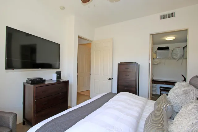 a bedroom with a bed and a flat screen tv