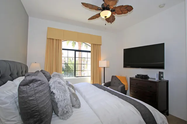 a bedroom with a bed and a flat screen tv