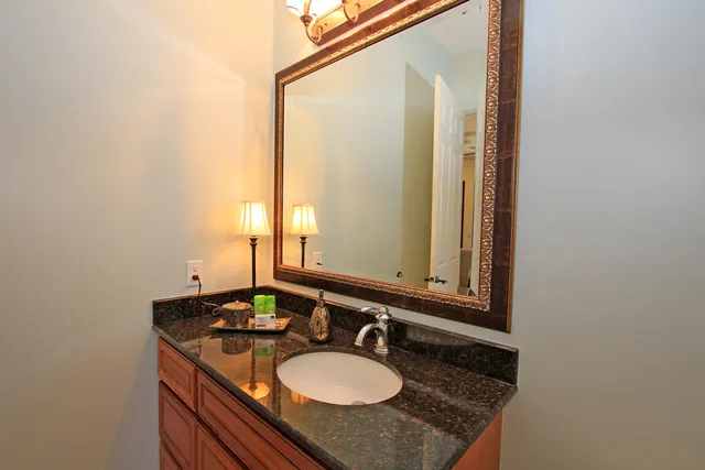 a bathroom with a granite countertop sink and a mirror