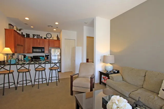 a living room with furniture kitchen view and a large window