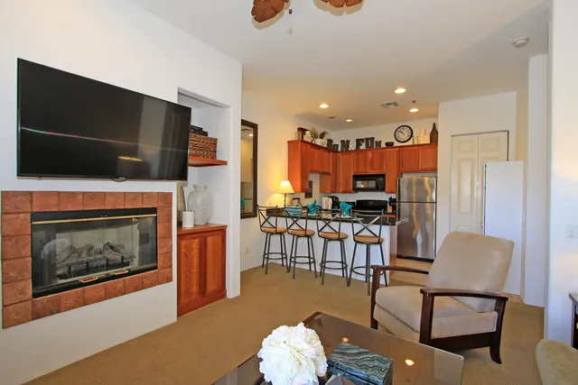 a living room with furniture a flat screen tv and a fireplace
