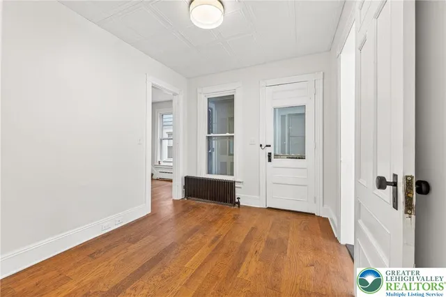 a view of a hallway with wooden floor and staircase