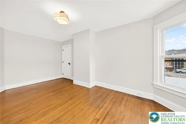 a spacious bedroom with a bed and a lamp