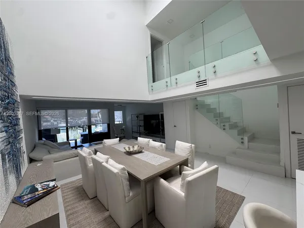a open kitchen with stainless steel appliances kitchen island granite countertop a sink and a refrigerator