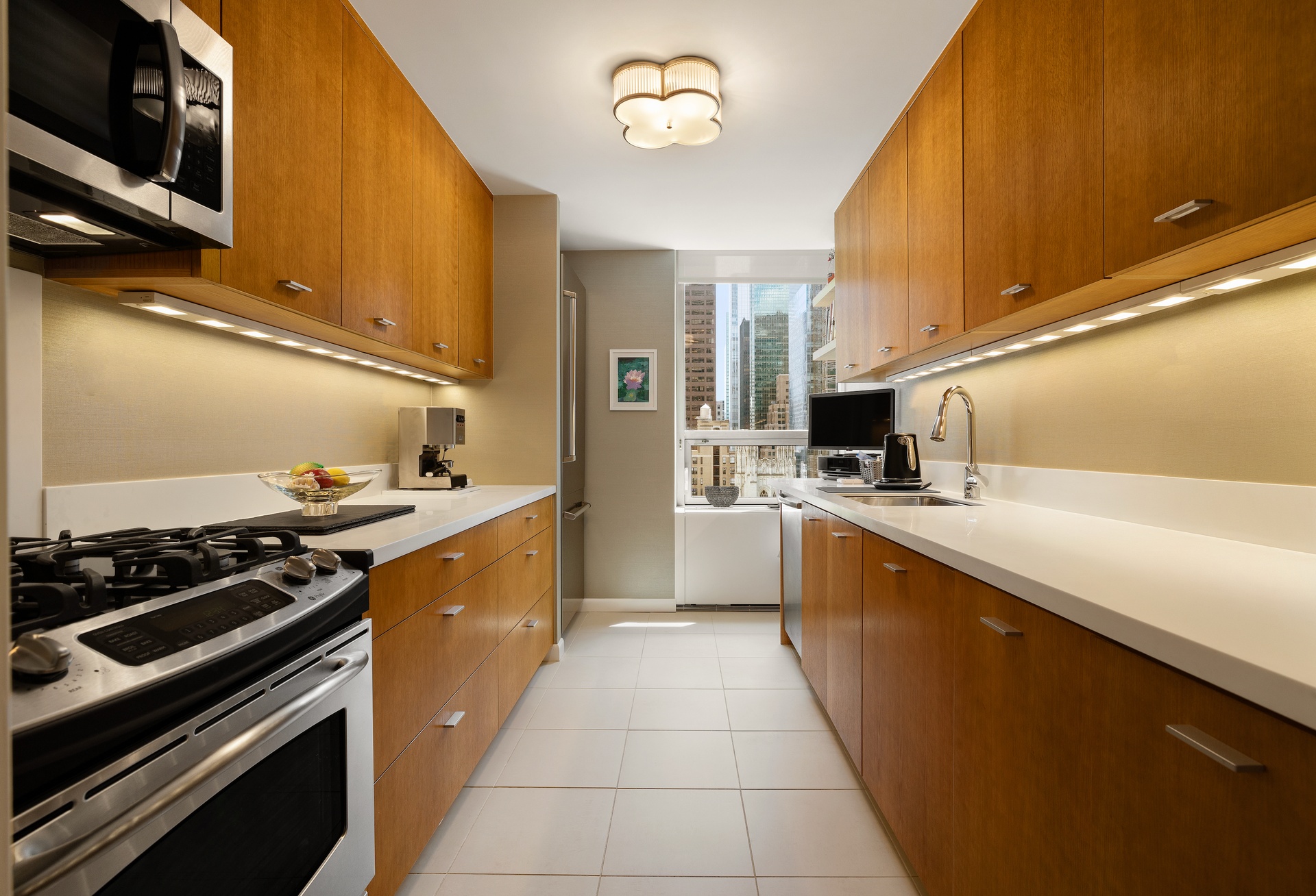 15 West 53rd Street, Unit 14G Manhattan, NY 10019 - Photo 5 of 10 a large kitchen with stainless steel appliances granite countertop a stove a sink and a microwave