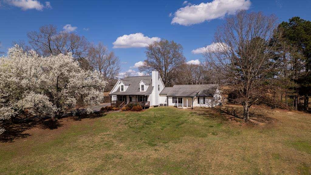 a view of a house with a yard and tree s