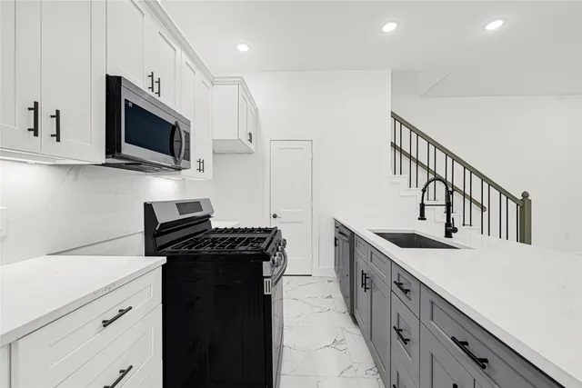 a kitchen with stainless steel appliances a stove microwave and a refrigerator