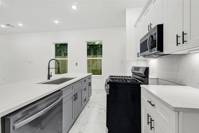 a kitchen with a sink stove and microwave