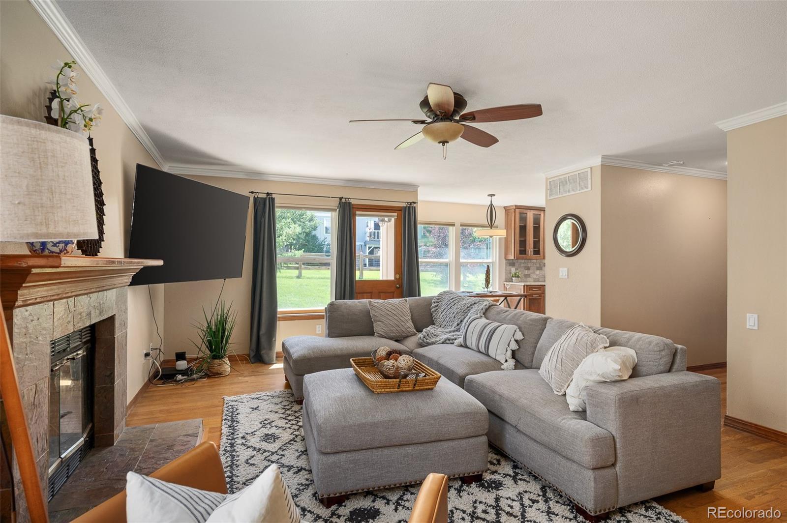 7412 Berkeley Court Castle Pines, CO 80108 - Photo 12 of 37 a living room with furniture ceiling fan and a fireplace